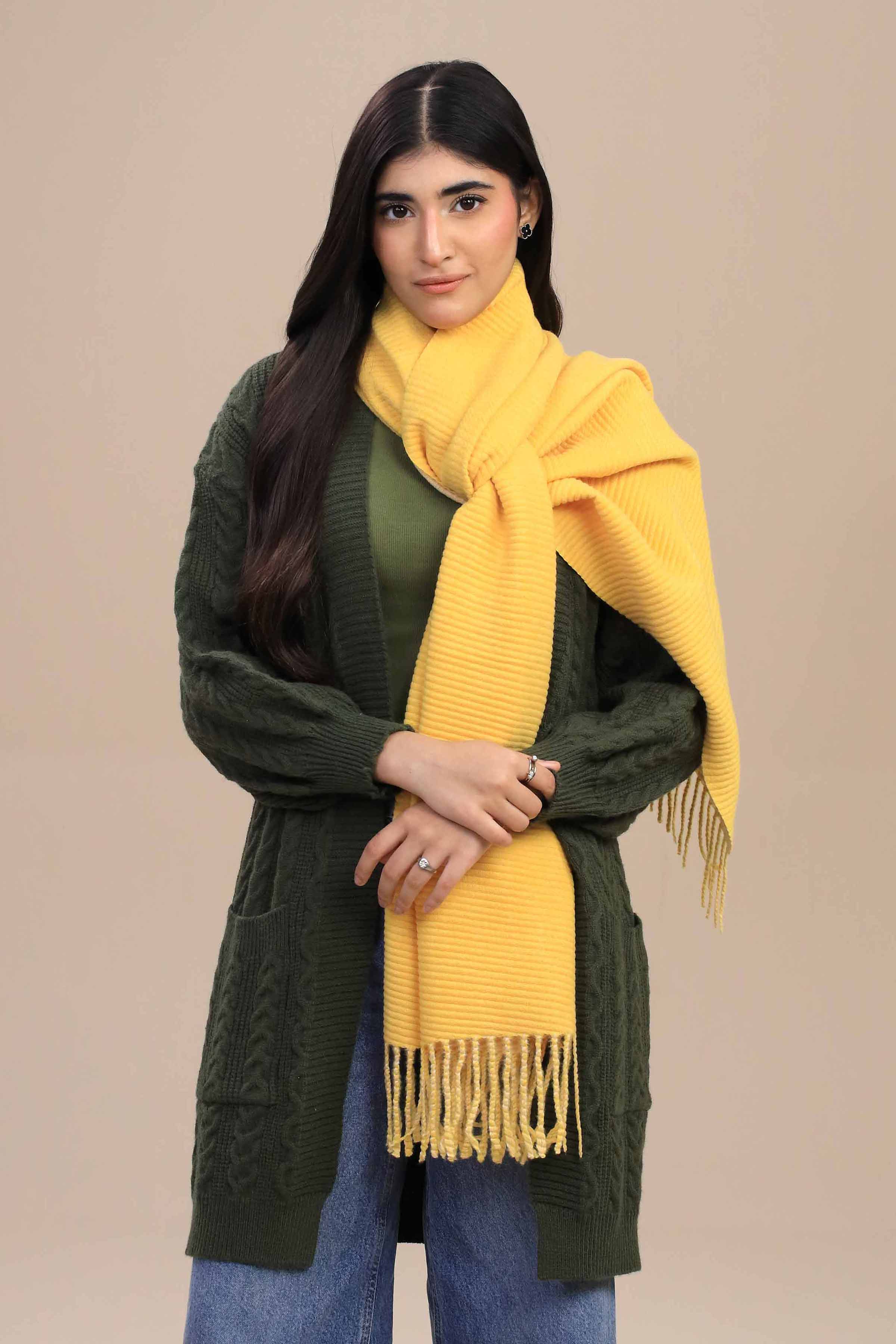 Woman wearing a green cardigan and yellow scarf