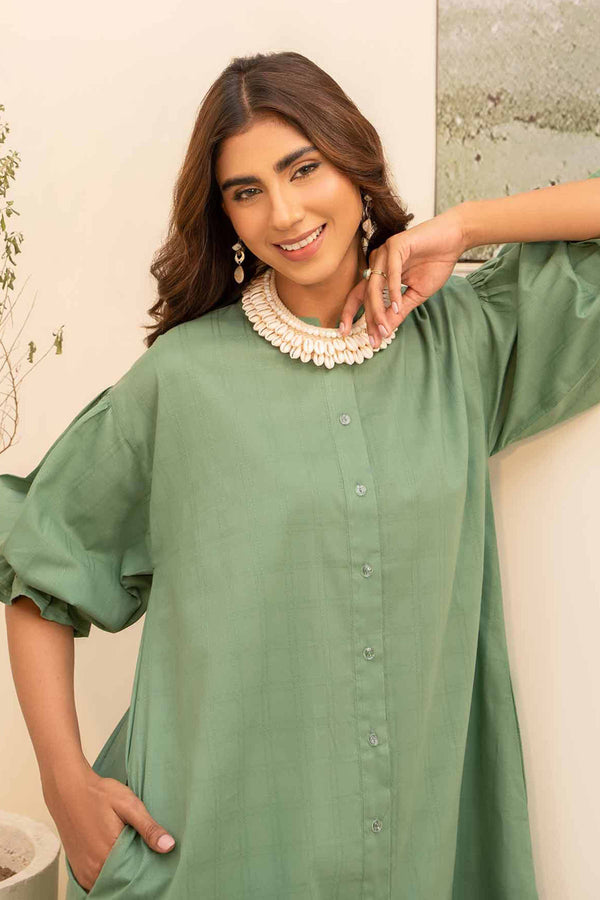 A woman in a jacquard jade green shirt exuding confidence and style.